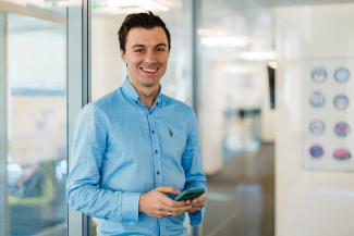 Young man with smartphone smiling