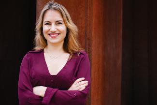 woman facing camera smiling with arms crossed