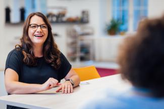 portrait of brunette woman with glasses laughing