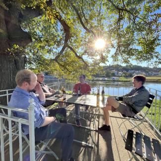 group of men sitting in the sun with beer