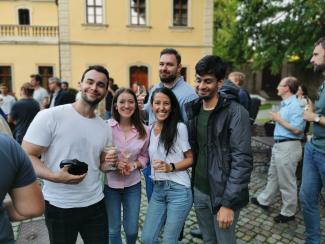 people posing for pictures holding glasses of wine