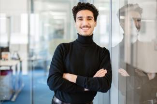 young men leaning on a wall smiling